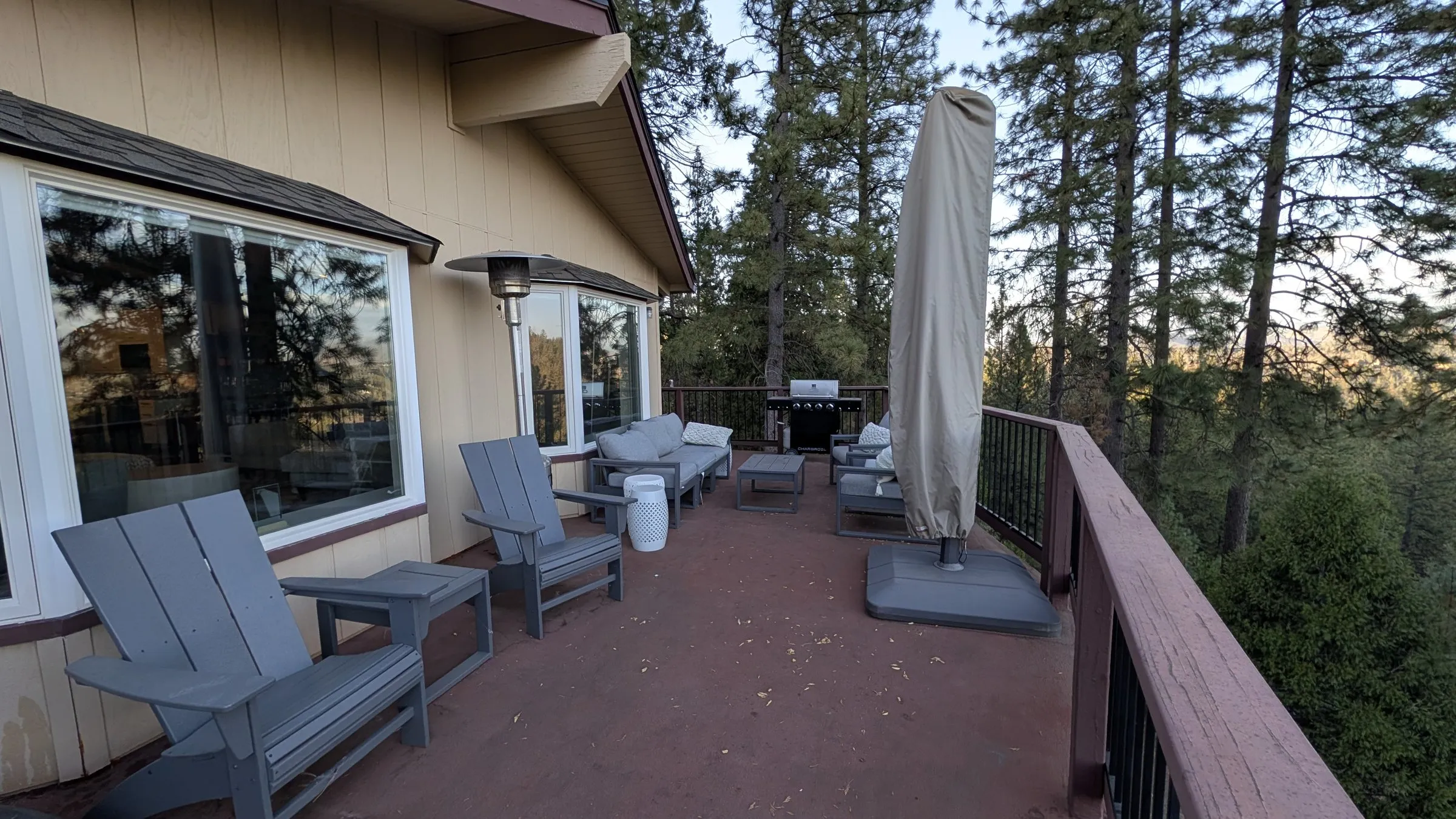 Adirondack chairs, patio heater and umbrella along the long deck