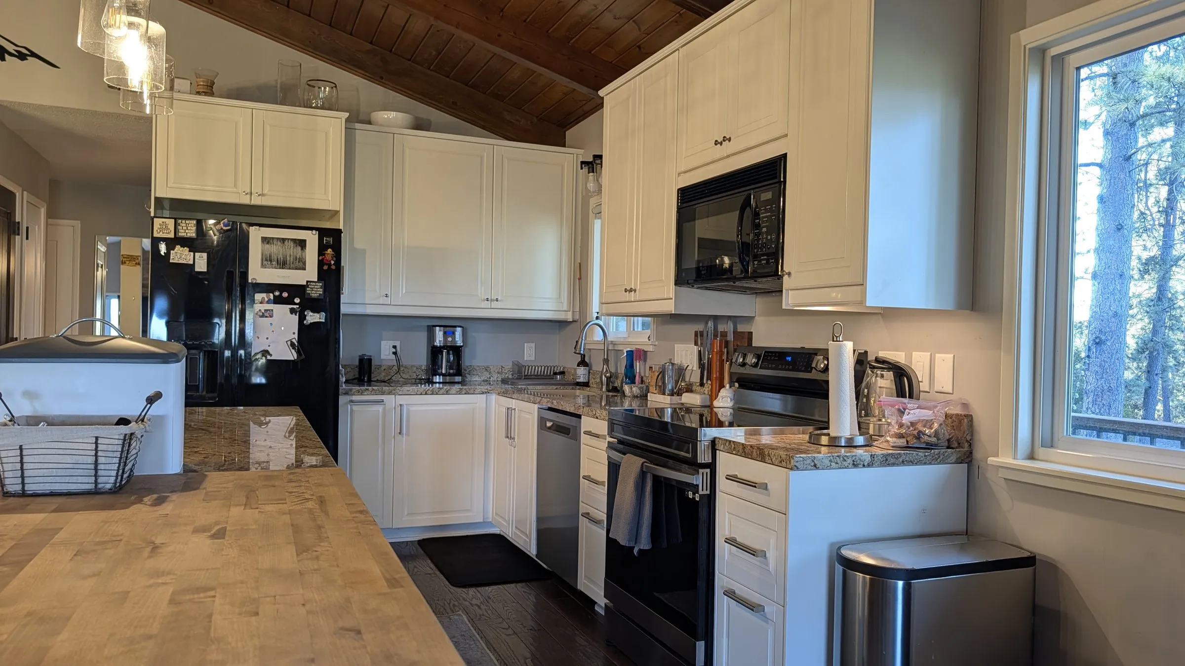White kitchen with butcher-block counter and stainless appliances