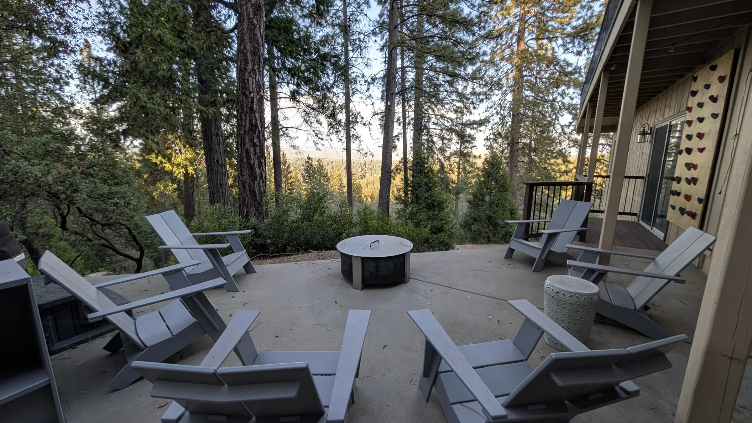 Lower patio with Adirondack chairs circled around a fire pit