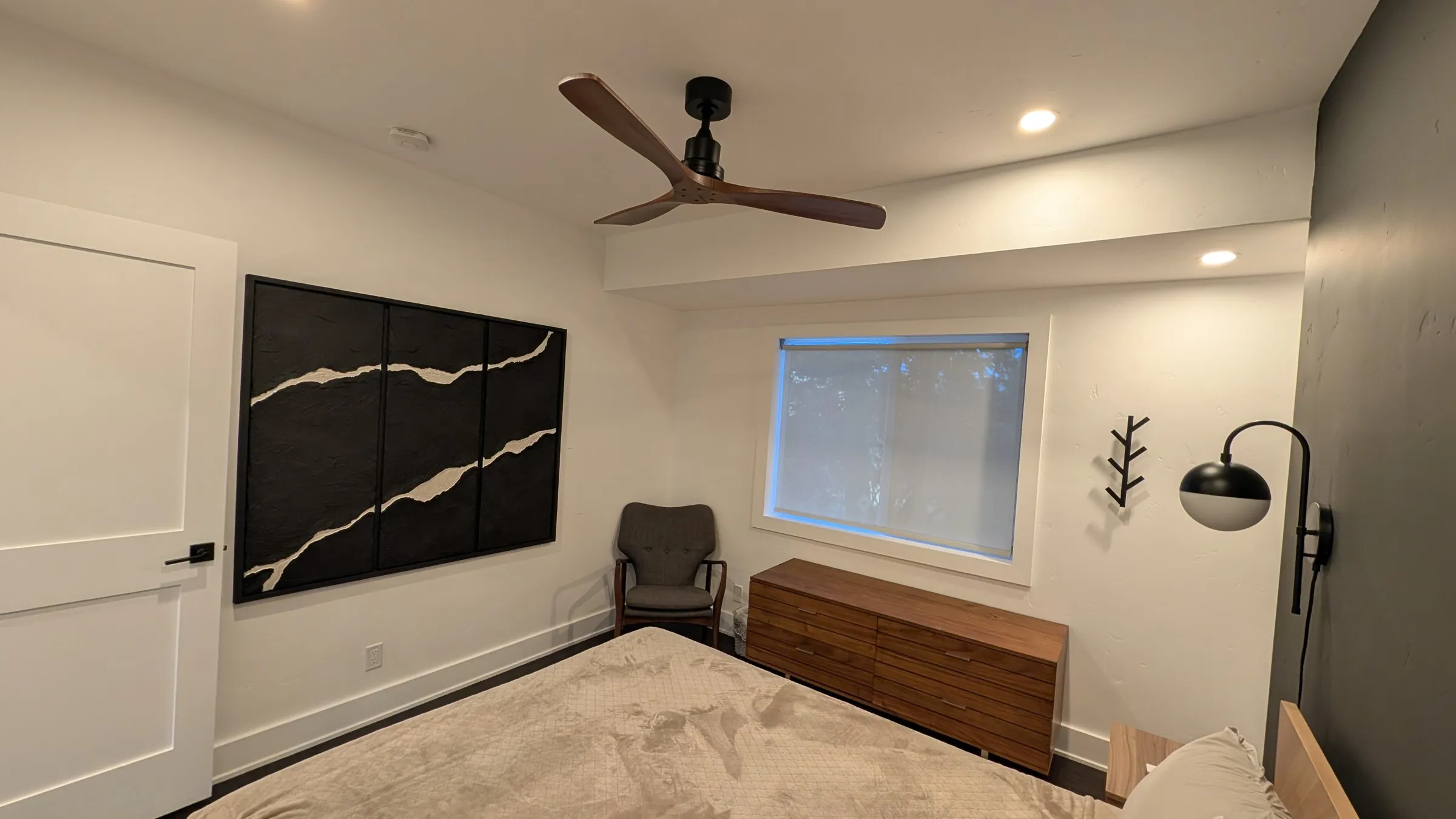 Queen room with black-and-white art and reading chair