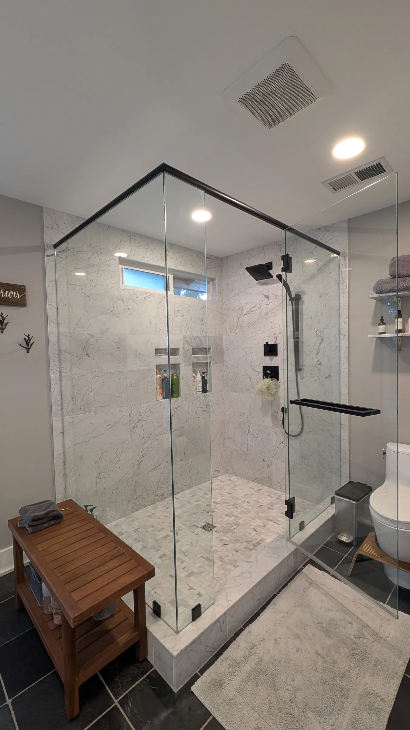 Large marble walk-in shower with glass walls