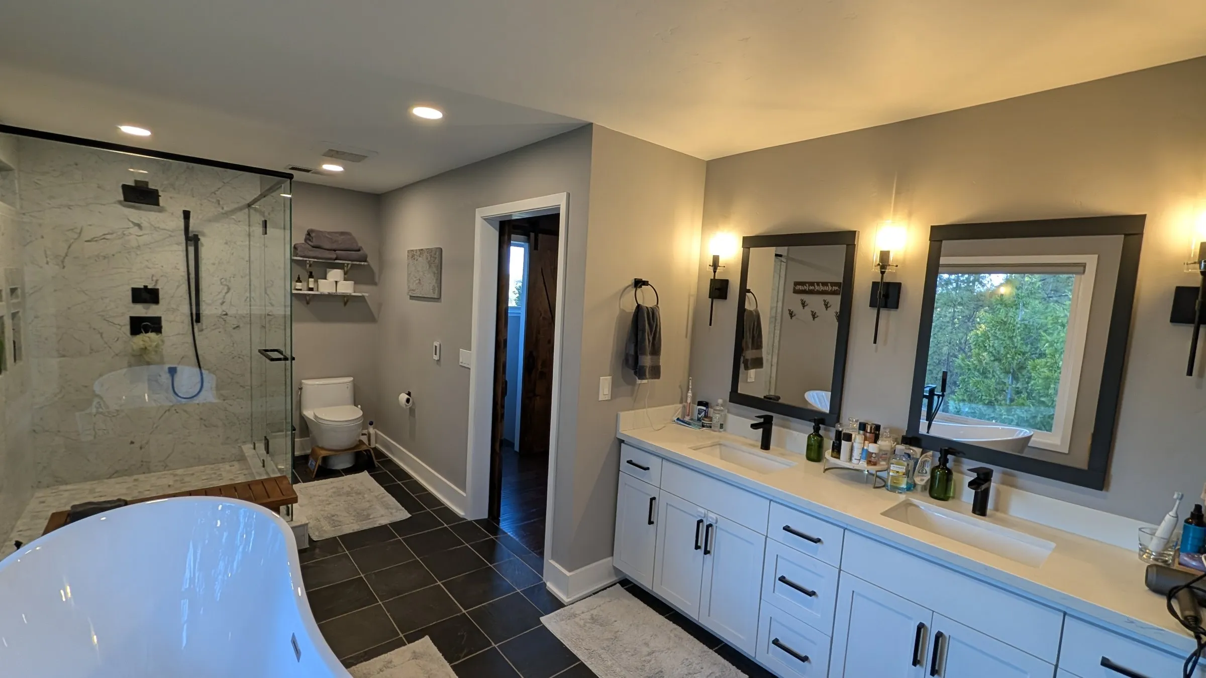 Double vanity with black mirrors and sconces